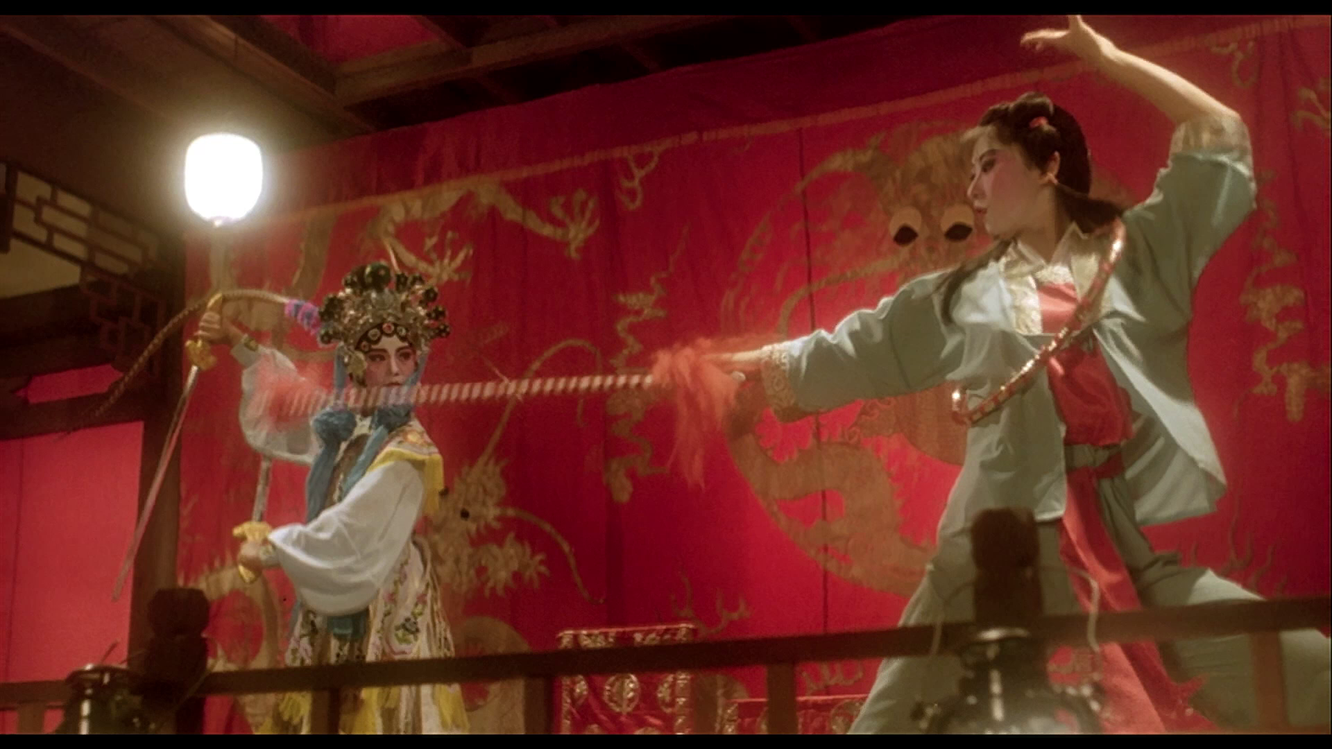 Two Chinese opera performers engage in a staged sword fight in Peking Opera Blues