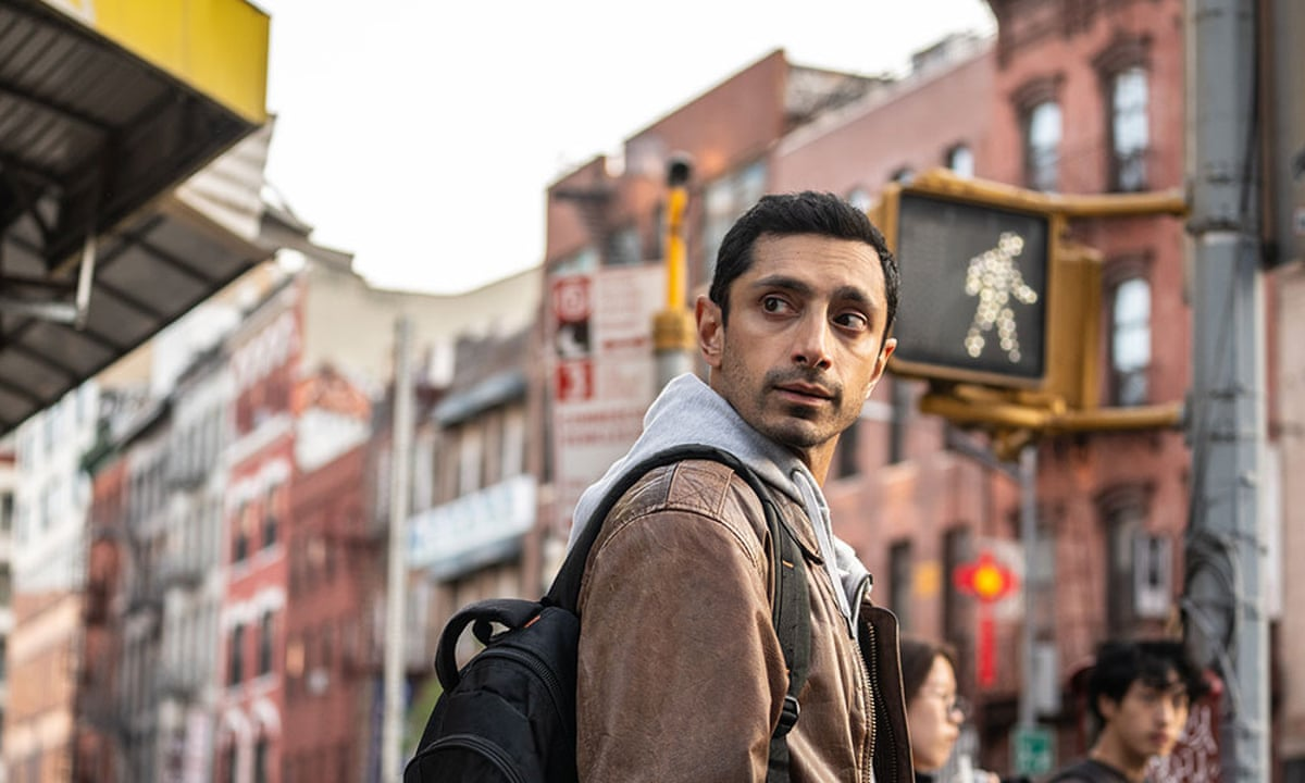 Riz Ahmed looks over his shoulder near a crosswalk in Relay