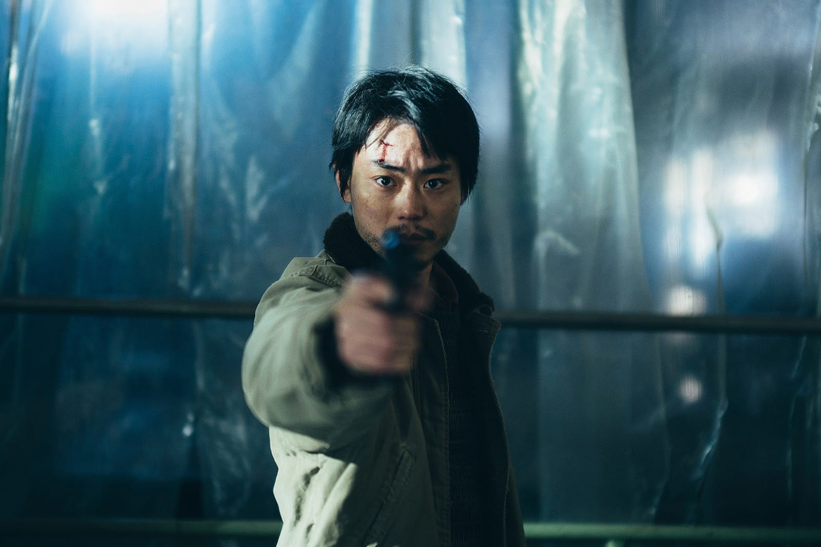 Masaki Suda points a gun at the camera in Cloud