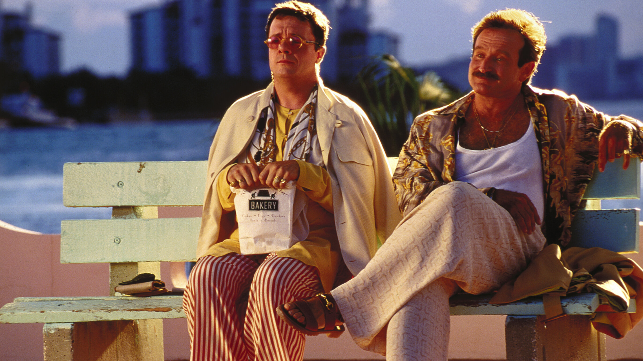 Nathan Lane and Robin Williams dressed to their Miami best on a bench in The Birdcage