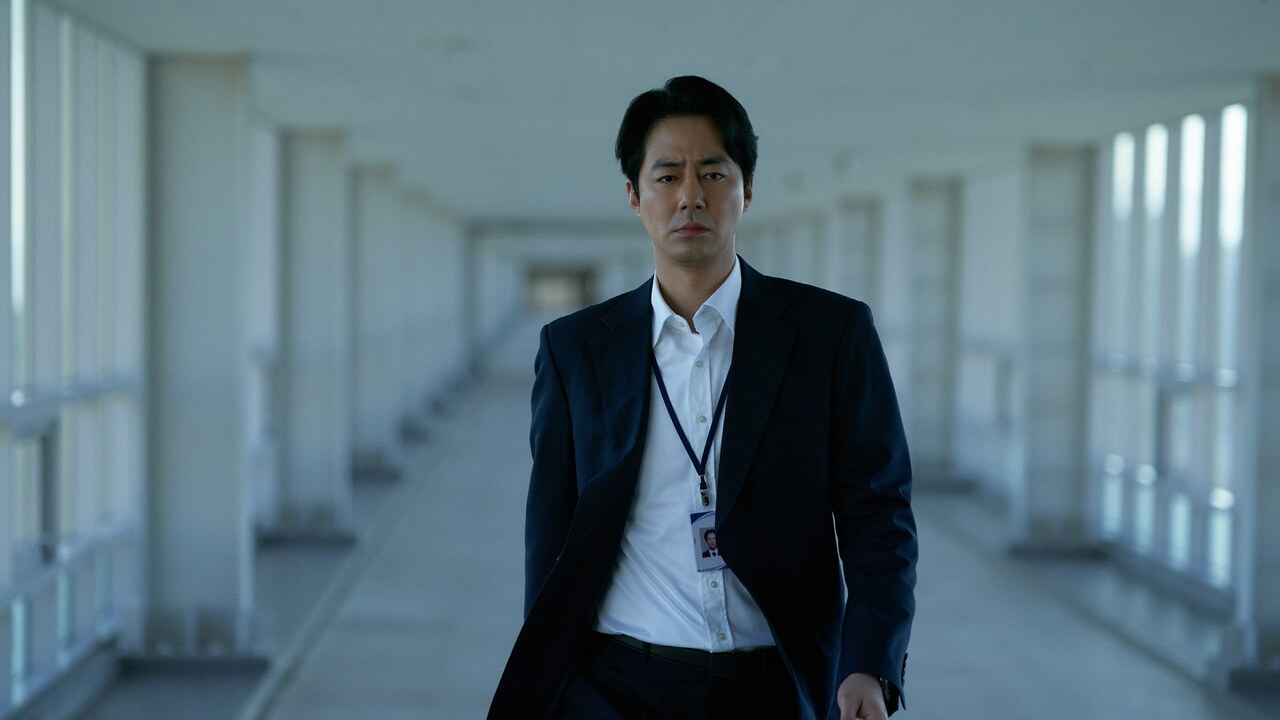 In Humint, Zo In-sung wears a suit and walks odwn an empty hallway