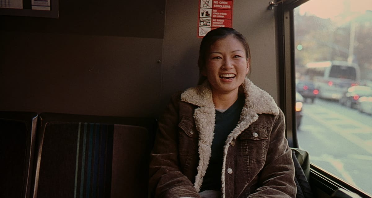 Michelle Krusiec smiling on a bus in Saving Face