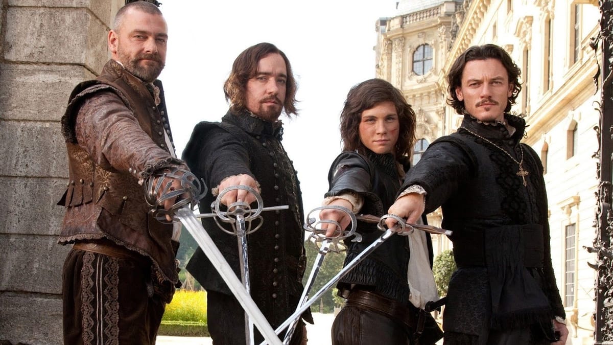 The musketeers in The Three Musketeers (2011) cross their swords and look at the camera
