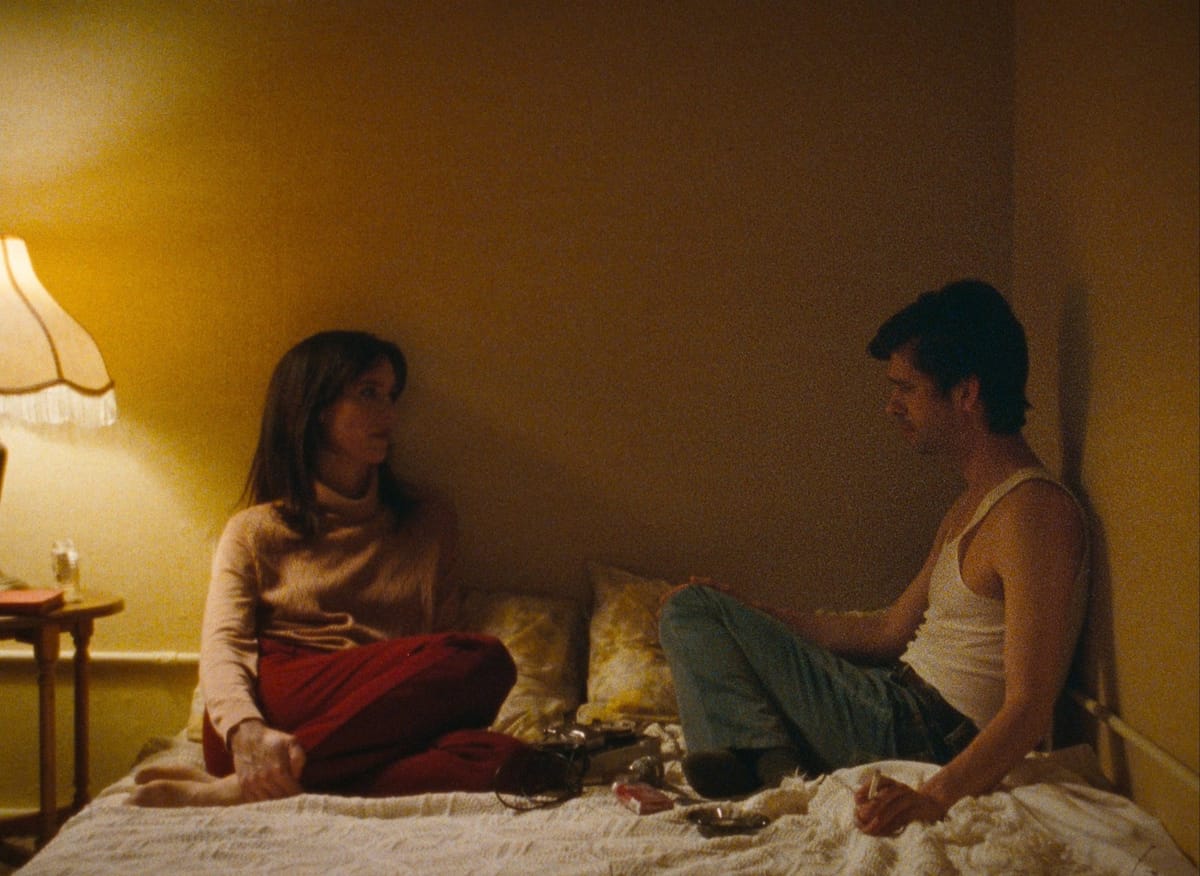 Rebecca Hall and Ben Whishaw sit on a bed together in Peter Hujar's Day