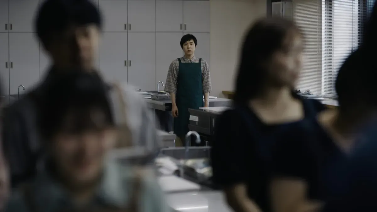 In Chime, a man in a cooking class stands creepily, at a distance from the other students