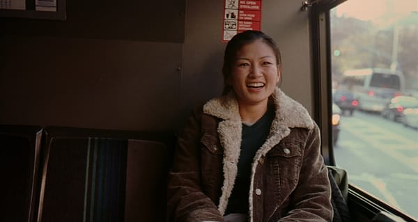 Michelle Krusiec smiling on a bus in Saving Face